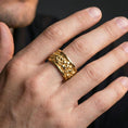 Load image into Gallery viewer, Gold plated skull cuff ring worn on a finger, lifestyle photo featuring warm tone finish and strong statement ring presence.