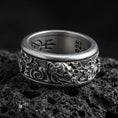 Load image into Gallery viewer, Oxidized oriental dragon band ring on textured volcanic rock, centered close-up highlighting the fierce dragon head relief, swirling cloud motifs, and deep antique shadowed contrast.