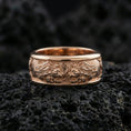 Load image into Gallery viewer, Rose gold plated twin lion band ring on textured volcanic rock, centered studio-style close-up showcasing soft rosy glow and intricate lion-and-mane detailing with a refined finish.