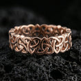 Load image into Gallery viewer, Rose gold plated Celtic triquetra chain-link ring on textured volcanic rock, centered studio-style close-up showcasing soft rosy glow and crisp interwoven knot detailing with a refined finish.