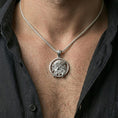 Load image into Gallery viewer, Polished silver Jesus medallion with side profile portrait and crown of thorns worn on the neck in a close lifestyle frame, highlighting the sculpted relief and circular design