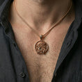 Load image into Gallery viewer, Rose gold plated religious Jesus pendant with circular portrait and crown of thorns worn on the neck in a refined lifestyle shot with a warm and elegant presentation
