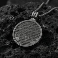 Load image into Gallery viewer, Oxidized Last Supper pendant with Pray for Us inscription, detailed round medallion design, and two-sided devotional concept displayed on dark volcanic rock in a close-up luxury jewelry composition