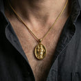 Load image into Gallery viewer, Gold plated Saint Dominic necklace with saint figure and book motif worn on the neck in a premium lifestyle composition with classic Christian jewelry styling