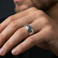 Load image into Gallery viewer, Polished silver hieroglyph band ring worn on a finger, lifestyle shot capturing the glossy silver finish and clear Egyptian glyphs in natural light.