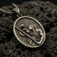 Load image into Gallery viewer, Bronze Saint Christopher pendant with Child Jesus, staff detail, and oval devotional portrait displayed on dark volcanic rock in a close-up luxury jewelry composition