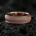 Load image into Gallery viewer, Rose gold plated geometric weave band ring on volcanic stone, refined macro shot featuring soft rose highlights and the precise geometric weave relief.