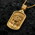Load image into Gallery viewer, Gold plated Jesus Christ pendant with detailed crown of thorns relief, flowing hair, and geometric engraved background showcased on black volcanic rock in a refined macro jewelry image