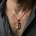 Load image into Gallery viewer, Rose gold plated religious Jesus pendant with detailed Christ face and crown of thorns worn on the neck in a refined lifestyle shot with a warm and elegant presentation