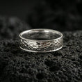 Load image into Gallery viewer, Polished silver hammered texture band ring on volcanic stone, clean studio macro highlighting crisp hammered pattern, bright reflections, and smooth comfort edges.