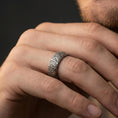 Load image into Gallery viewer, Oxidized sterling silver wave pattern band ring worn on a finger, lifestyle wear image focusing on bold contrast, sculpted texture, and everyday styling.