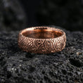 Load image into Gallery viewer, Rose gold plated wave pattern band ring on volcanic stone, elegant macro close-up capturing soft rose reflections over the wave motif and rounded silhouette.