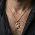 Load image into Gallery viewer, Rose gold plated Orthodox Christian Saint Anastasia pendant with devotional figure and oval medallion form worn on the neck in a refined lifestyle shot with a warm and elegant presentation