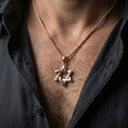 Load image into Gallery viewer, Rose gold plated Star of David necklace with open hexagram design worn on the neck in a refined lifestyle shot with a warm and elegant presentation