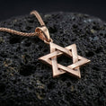Load image into Gallery viewer, Rose gold plated Star of David necklace with open six-pointed star form, polished geometric relief, and timeless symbolic design resting on volcanic rock in an elegant close-up product presentation