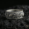 Load image into Gallery viewer, Oxidized sterling silver koi fish band ring on volcanic stone, macro close-up emphasizing the raised koi relief, wave engravings, and antique contrast.