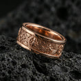 Load image into Gallery viewer, Rose gold plated spinner ring on volcanic stone, refined macro close-up showcasing soft rose reflections, raised round accents, and sculpted knotwork lines.