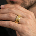 Load image into Gallery viewer, Gold plated sci-fi band ring worn on the finger, lifestyle photo emphasizing luxury warmth, futuristic design language, and a confident statement profile.