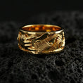 Load image into Gallery viewer, Gold plated guitar ring on volcanic stone, luxury macro photo capturing warm golden tone across the guitar body, strings, and textured relief.