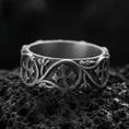 Load image into Gallery viewer, Oxidized sterling silver quatrefoil cross band ring on volcanic stone, macro close-up showing darkened recessed background and raised cross medallion details.