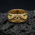 Load image into Gallery viewer, Gold plated protective eye ring on volcanic stone, luxury macro photo capturing warm gold tone across the hands and the central all-seeing eye motif.
