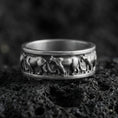 Load image into Gallery viewer, Oxidized sterling silver horse band ring on volcanic stone, macro close-up highlighting the darkened recesses and raised running-horse relief around the band.