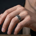 Load image into Gallery viewer, Gothic cross spinner ring worn on a finger, oxidized sterling silver look with bold shadows that make the raised crosses stand out clearly.