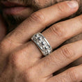 Load image into Gallery viewer, Skull motif sterling silver band ring worn on a finger, polished silver look with crisp reflections that make the skull relief stand out.