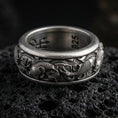 Load image into Gallery viewer, Koi fish sterling silver band ring on black volcanic stone, photographed with an oxidized finish to emphasize contrast in the carved scales and flowing water waves.