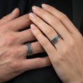Load image into Gallery viewer, Sterling silver Celtic knot band ring worn on a finger, oxidized sterling silver look with strong contrast that makes the interlaced Celtic pattern read clearly.