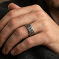 Load image into Gallery viewer, Celtic knot spinner band ring worn on a finger, oxidized sterling silver finish creating strong contrast for the Celtic braid details.