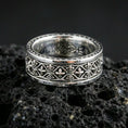 Load image into Gallery viewer, Gothic fleur-de-lis band ring on black volcanic stone, shown in a polished silver finish with crisp reflective edges across the raised fleur-de-lis pattern.