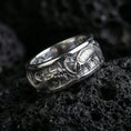 Load image into Gallery viewer, Polished silver dragon and koi fish wedding band on black volcanic stone, crisp sculpted relief with deep carved background, centered close-up studio lighting.