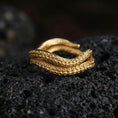 Load image into Gallery viewer, Gold plated octopus tentacle wrap ring on volcanic rock, detailed suction cup pattern and coiled shape, luxury jewelry product photography.