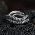 Load image into Gallery viewer, Oxidized sterling silver octopus tentacle wrap ring on dark volcanic rock, suction cup texture detail, premium macro product shot.