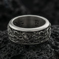 Load image into Gallery viewer, Oxidized sterling silver spinning wave band ring on dark volcanic rock, nautical ocean swirl engraving with bold relief detail, premium macro product shot.