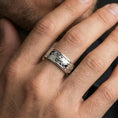 Load image into Gallery viewer, Polished silver fidget spinner cloud and flower band ring on finger, crisp swirl relief and smooth edges, refined everyday wear close-up.