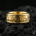 Load image into Gallery viewer, Gold plated geometric circle pattern spinner ring on volcanic rock, detailed round motifs on rotating band, luxury jewelry product photography.