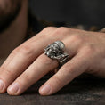 Load image into Gallery viewer, Oxidized sterling silver biker skull ring worn on finger, helmet and goggles relief detail, natural lifestyle hand shot with shallow depth of field.
