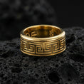 Load image into Gallery viewer, Gold plated Greek key pattern band ring on volcanic rock, classic meander motif with clean engraved lines, luxury jewelry product photography.