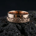 Load image into Gallery viewer, Rose gold plated sterling silver mountain skyline band on volcanic stone, engraved Grand Teton peaks with deep contrast detail, minimal high-end close-up.