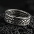 Load image into Gallery viewer, Oxidized sterling silver braided rope texture band ring on dark volcanic rock, woven pattern with dotted edge detail, premium macro product shot.