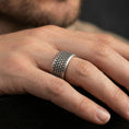 Load image into Gallery viewer, Oxidized sterling silver scale texture band worn on finger, repeating scale pattern detail, natural lifestyle hand shot with shallow depth of field.