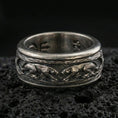 Load image into Gallery viewer, Oxidized sterling silver jaguar spinner band ring on dark volcanic rock, engraved big cat relief on rotating center with textured background, premium macro product shot.