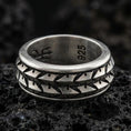 Load image into Gallery viewer, Oxidized sterling silver arrowhead spinner band ring on dark volcanic rock, tribal geometric chevron pattern on rotating center, premium macro product shot.