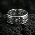 Load image into Gallery viewer, Polished silver octopus fidget spinner ring on black volcanic stone, crisp octopus relief detail with smooth comfort edges, centered close-up studio lighting.