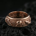 Load image into Gallery viewer, Rose gold plated sterling silver skull and koi spinner ring on volcanic stone, sculpted skull relief with carp and wave motifs in deep contrast, minimal high-end close-up.