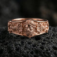 Load image into Gallery viewer, Rose gold plated sterling silver Zeus band on volcanic stone, sculpted bearded deity portrait with deep contrast and ornamental side panels, minimal high-end close-up.