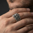 Load image into Gallery viewer, Oxidized sterling silver lion head signet worn on finger, roaring lion relief and scrollwork shoulder detail, natural lifestyle hand shot with shallow depth of field.
