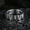 Load image into Gallery viewer, Polished silver geometric band ring on black volcanic stone, crisp angular wedge facets with bright highlights and brushed texture, centered close-up.